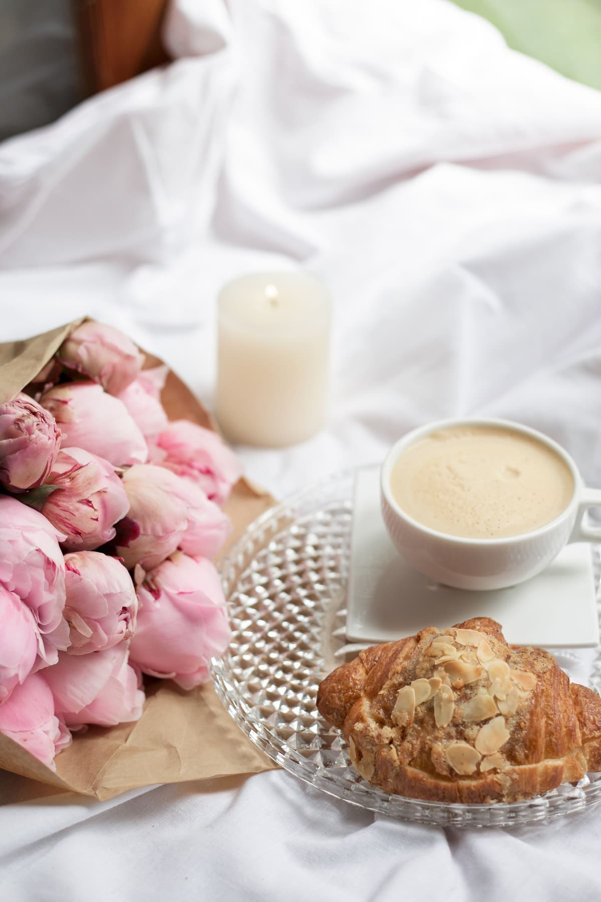 Morgenkaffee und Mandelcroissant mit Pfingstrosen