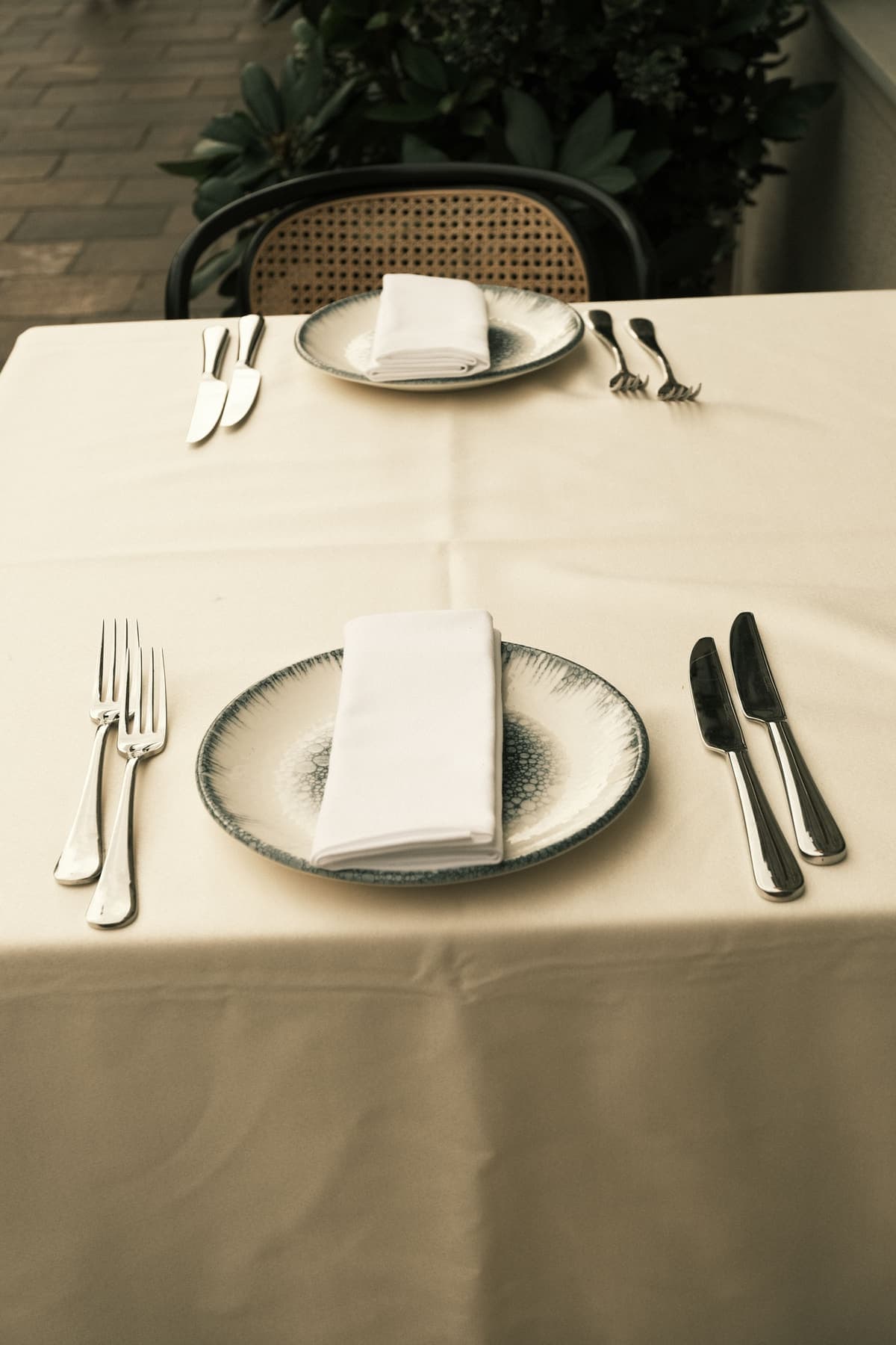 Sorgfältig eingedeckter Tisch mit weißer Tischdecke